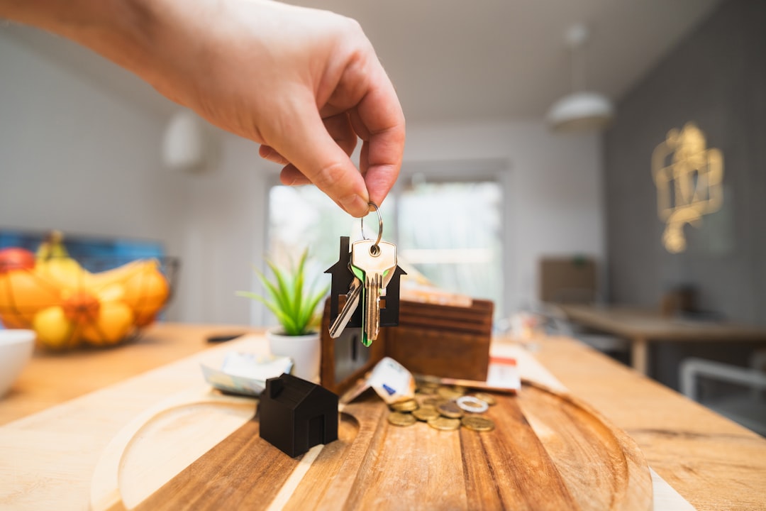 A person holding keys in a room with a piece of wood on top of a wooden table